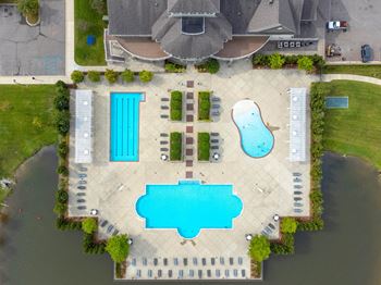 An aerial view of a pool and a swimming pool in front of a house